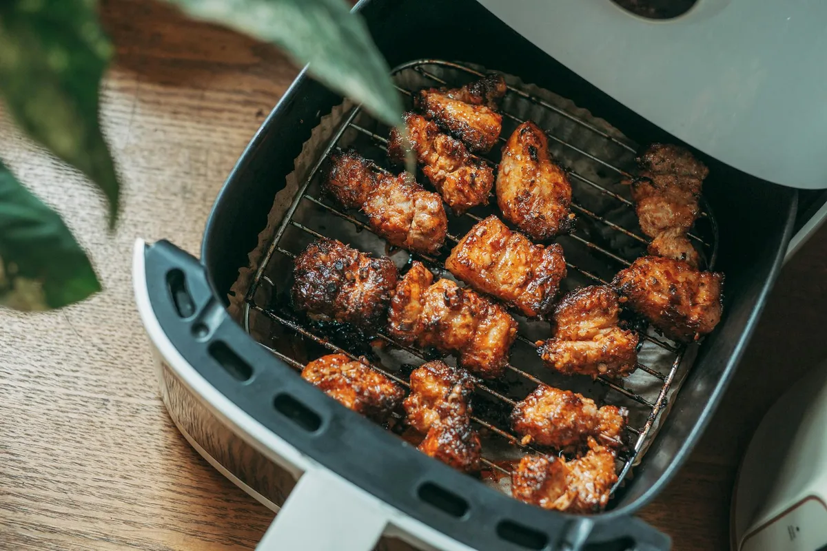 Air fryer basket with bacon arranged in single layer